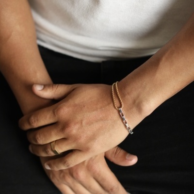 Pulseira dupla corrente dourada e prateada em punho masculino com anel dourado