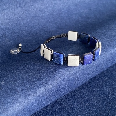 Pulseira com pedras quadradas azuis e brancas alternadas sobre fundo azul