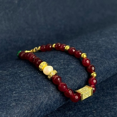 Pulseira com contas vermelhas, douradas e creme com fecho dourado cravejado