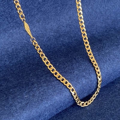 Corrente dourada com detalhe de asa sobre fundo azul