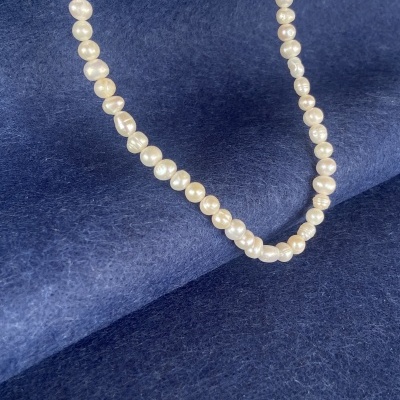 Colar de pérolas brancas sobre fundo azul