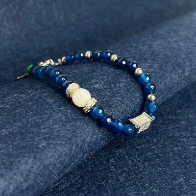 Pulseira com contas azuis e prateadas sobre tecido azul