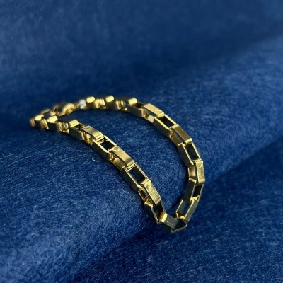 Pulseira dourada em tecido azul