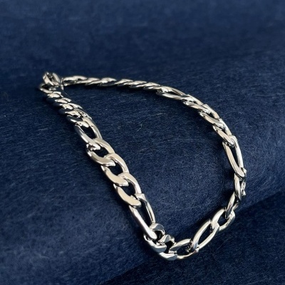 Pulseira de corrente prateada sobre fundo azul escuro