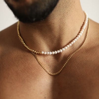Colar masculino triplo com pérolas e corrente dourada no pescoço de um homem