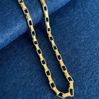 Colar dourado com detalhes pretos sobre tecido azul