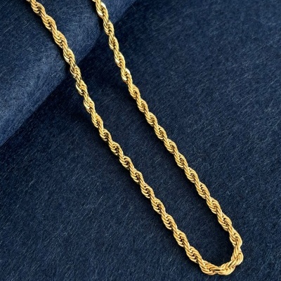 Corrente dourada entrelaçada sobre tecido azul escuro