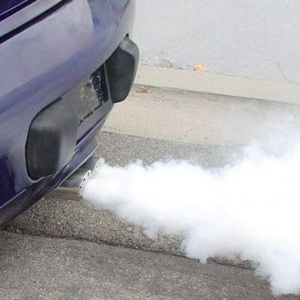 Escape de carro azul emitindo fumo branco