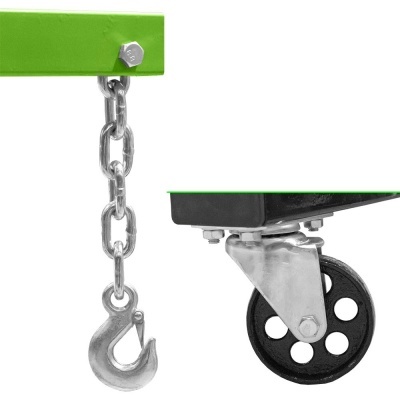 Gancho de metal pendurado em corrente e roda preta em suporte metálico sob estrutura verde