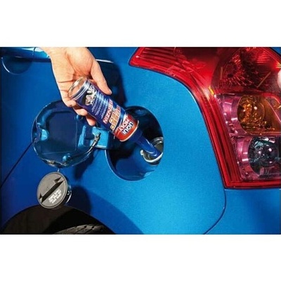 Frasco azul sendo despejado no depósito de um carro azul
