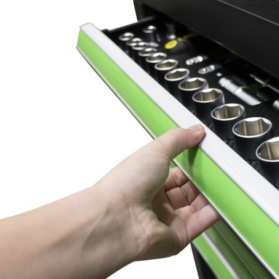 Gaveta verde de caixa de ferramentas com chaves soquetes metálicas e mão segurando.