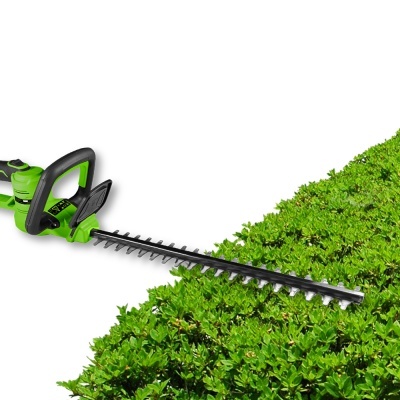 Tesoura para cerca viva elétrica verde com lâmina metálica sobre cerca viva verde