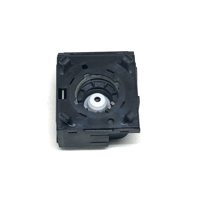 Peça plástica preta quadrada com engrenagem branca no centro