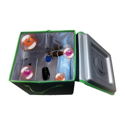 Cofre cinzento aberto com objetos e autocolantes no interior