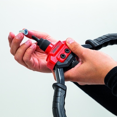 Ferramenta manual de aperto preta e vermelha segurada por mãos