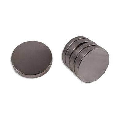 Ímanes metálicos circulares prateados dispostos em pilhas sobre fundo branco