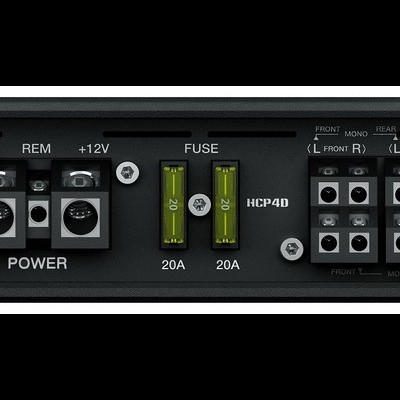 Amplificador de áudio preto com conexões e fusíveis visíveis