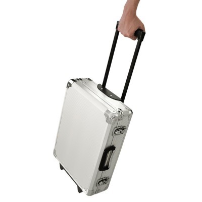 Mala rígida branca com reforços metálicos e duas fechaduras numa mão