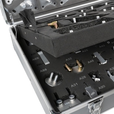 Estojo metálico com peças metálicas organizadas em espuma preta com códigos alfanuméricos