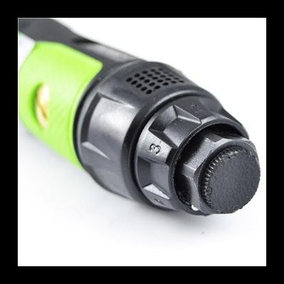 Detalhe de ferramenta elétrica verde e preta com botão rotativo numerado