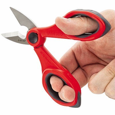 Tesoura vermelha com punho emborrachado segurada por uma mão