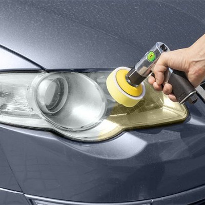 Carro cinzento com farol dianteiro a ser polido com ferramenta elétrica