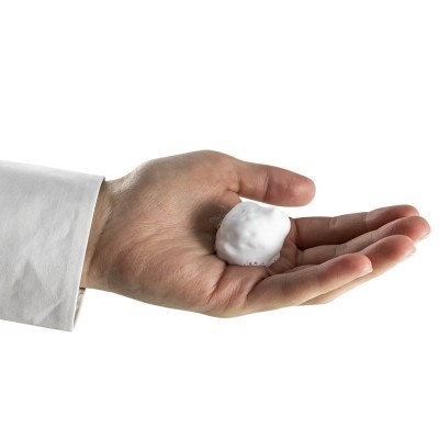 Mão segurando bola branca espumosa