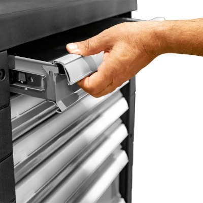 Mão a abrir gaveta de carrinho de ferramentas cinza e preto