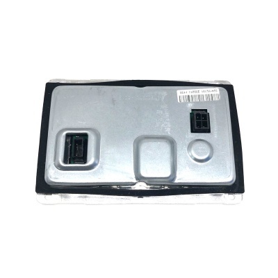 Peça metálica com encaixes pretos e etiqueta adesiva numa bancada branca