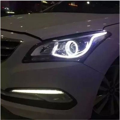 Farol dianteiro de carro branco com luzes LED acesas à noite