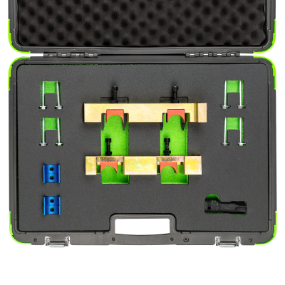 Estojo preto com peças metálicas verdes, azuis e douradas organizadas em interior de espuma