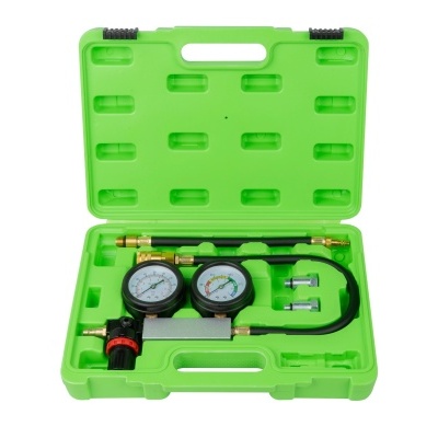 Conjunto de manómetro de pressão para gases em caixa verde aberta.