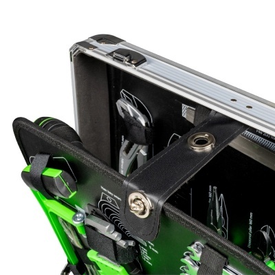 Estojo metálico aberto com ferramentas verdes e pretas organizadas no interior preto