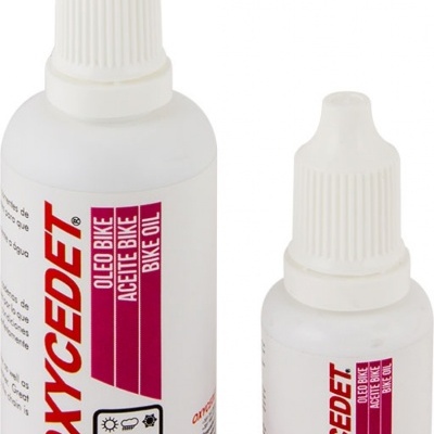 Duas embalagens brancas de óleo para bicicleta com rótulos com texto e ícones.