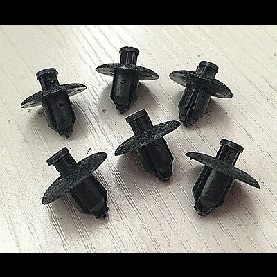 Seis presilhas de plástico preto com base circular sobre superfície clara