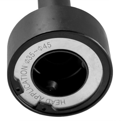 Cabeça de ferramenta preta com parte metálica circular e inscrição gravada.