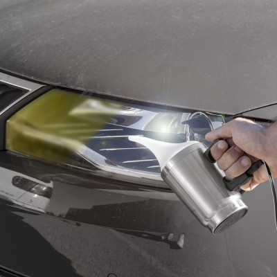 Pessoa a limpar farol de carro preto com dispositivo metálico a vapor