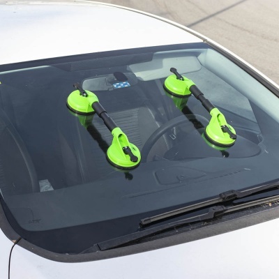 Dispositivo de ventosas verdes no para-brisas de carro branco