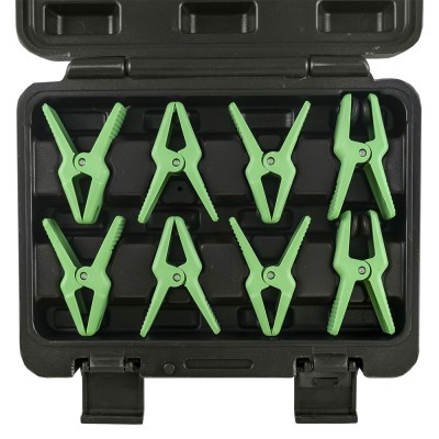 Oito grampos verdes organizados numa caixa preta.