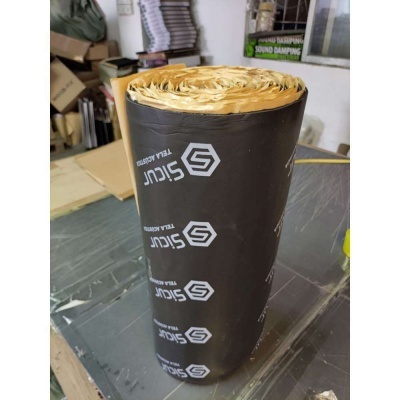 Rolo de isolante preto com interior amarelo e texto 'SICUR TELA ASFÁLTICA' num ambiente de armazém