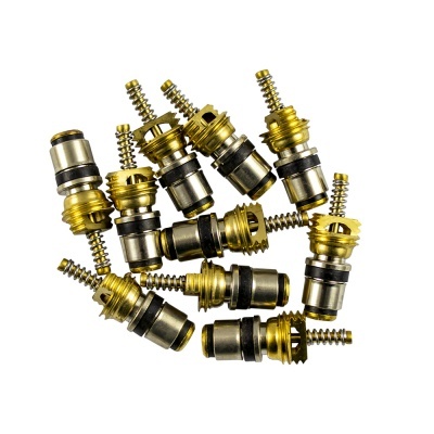 Peças metálicas douradas e prateadas com molas e anéis sobre fundo branco