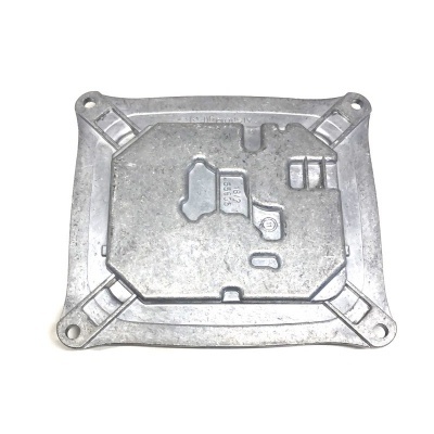 Peça metálica retangular com relevo geométrico e quatro buracos nos cantos