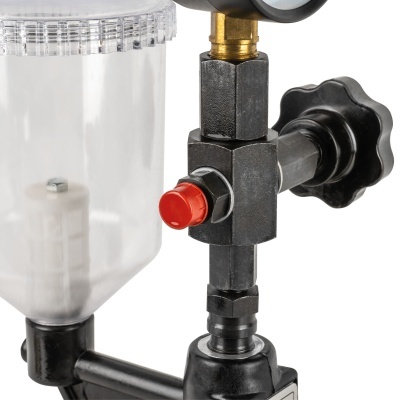 Equipamento com recipiente transparente, botão vermelho e componentes metálicos pretos e dourados