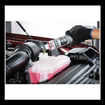 Frasco de líquidp para radiador sendo aplicado em motor de carro na oficina