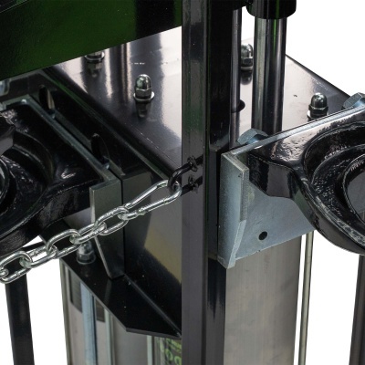 Equipamento metálico preto com corrente prateada e base circular texturizada.