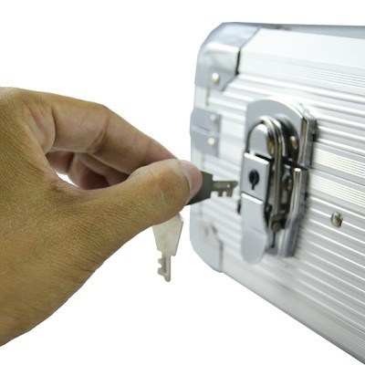 Mala metálica prateada com cadeado e chave em uso