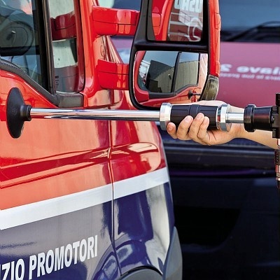 Máquina de soldar portátil a ser usada numa carrinha vermelha com letras parciais visíveis