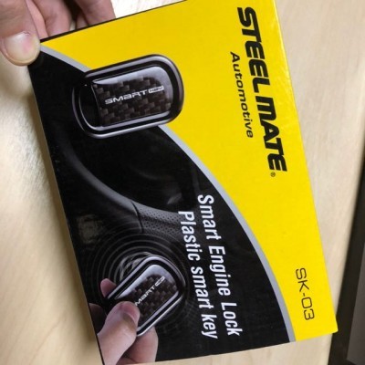 Embalagem amarela e preta do Steelmate Automotive SK-03 com chave inteligente plástica.