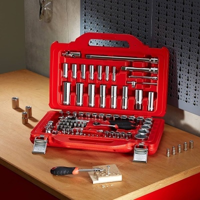 Estojo vermelho com conjunto de chaves soquetes metálicas sobre bancada de madeira