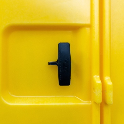 Fecho preto numa porta amarela de superfície lisa